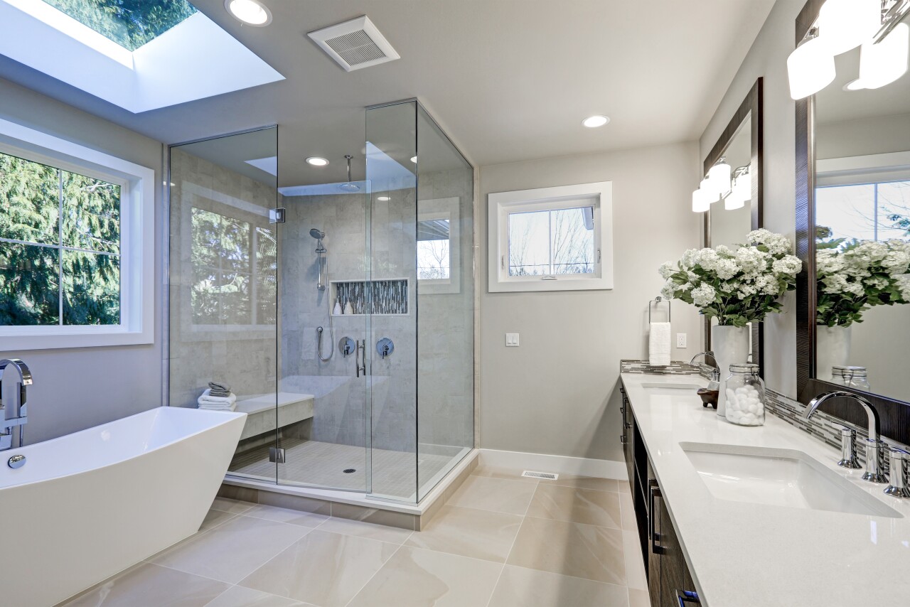 A brightly lit modern bathroom with brand new tile and furnishings.