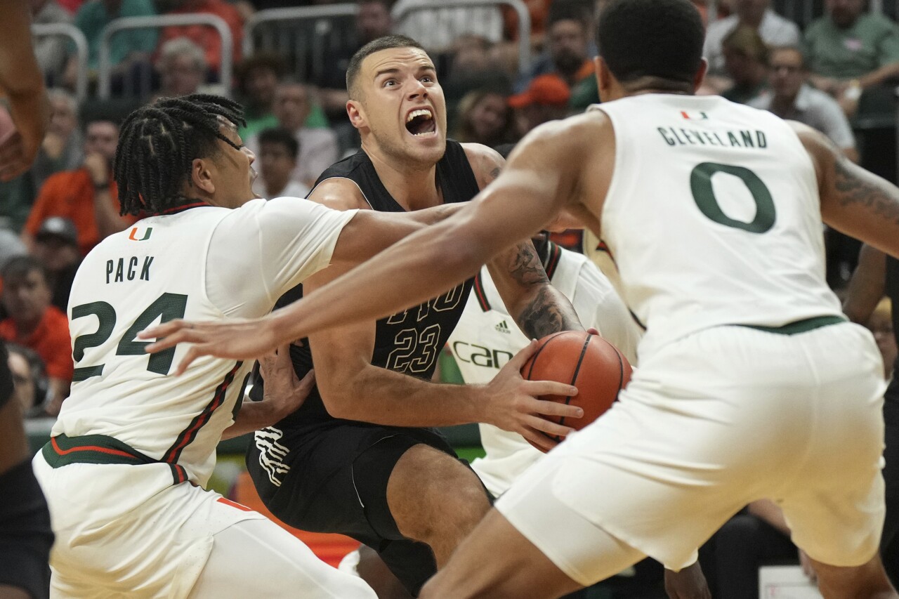 FIU Panthers guard Petar Krivokapic goes up for shot as Miami Hurricanes guards Nijel Pack and Matthew Cleveland defend, Nov. 13, 2023