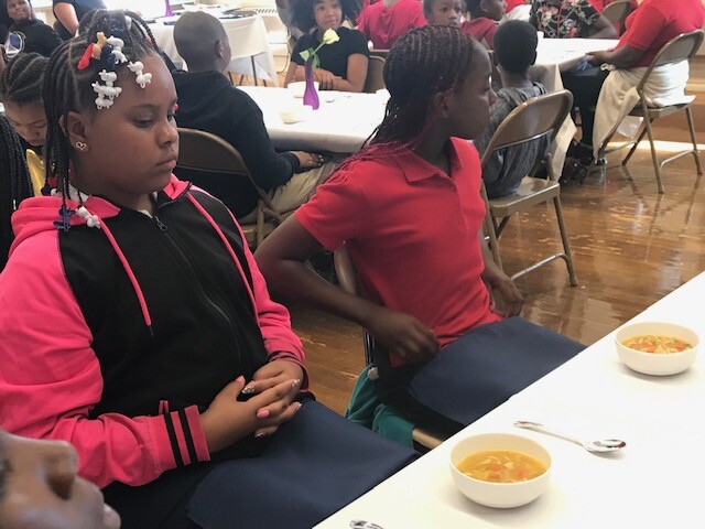 Students wait to eat their soup