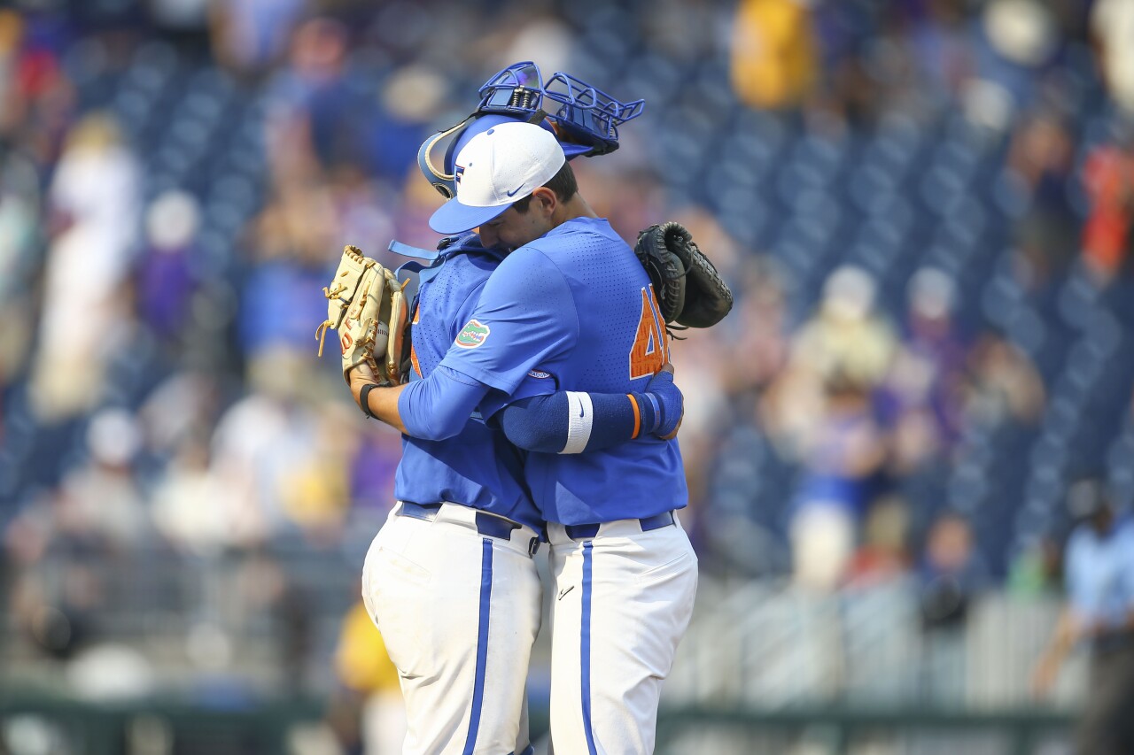 Florida Gators pitcher Nick Ficarrotta hugs catcher BT Riopelle after defeating LSU in second game of College World Series championship series, June 25, 2023