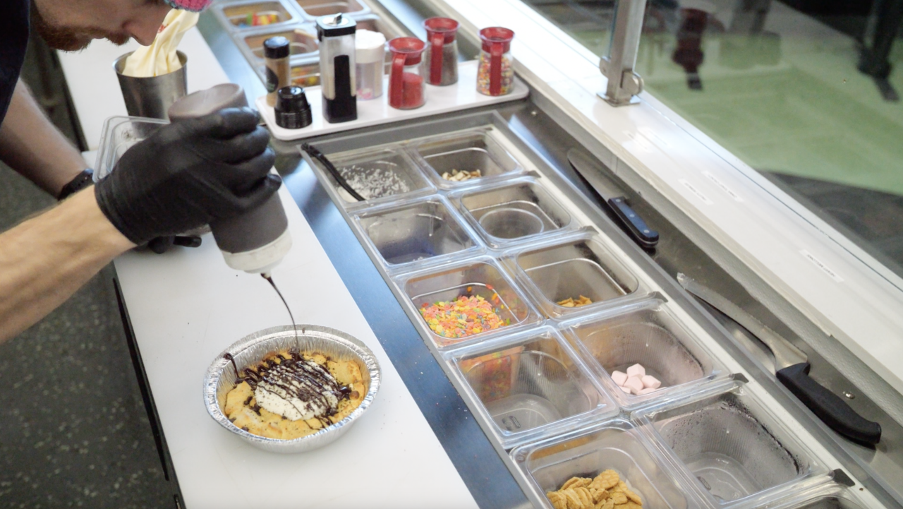 Right off the oven- Daniel Pace drizzles chocolate on a freshly baked cookie.