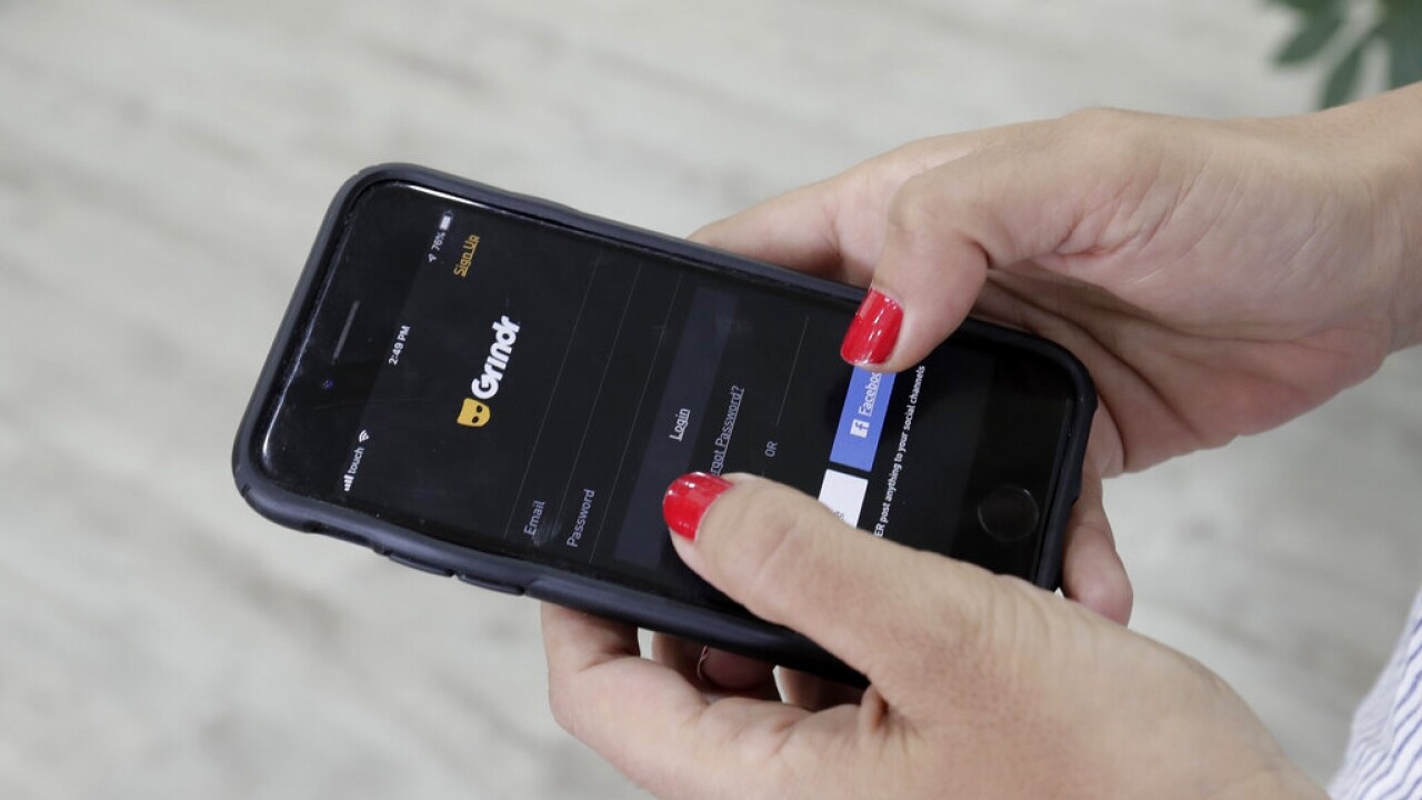 A person looks at the Grindr app on her mobile phone.
