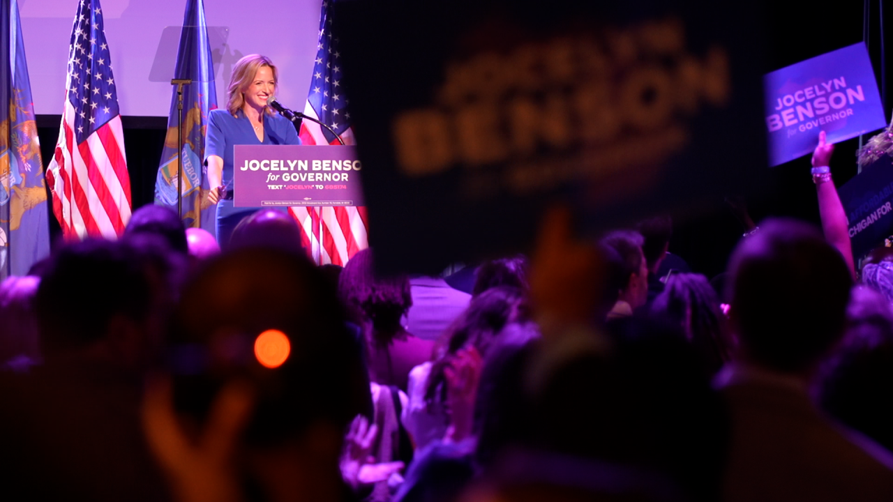 Jocelyn Benson victory speech with supporters holding signs at Garden Theater in Detroit