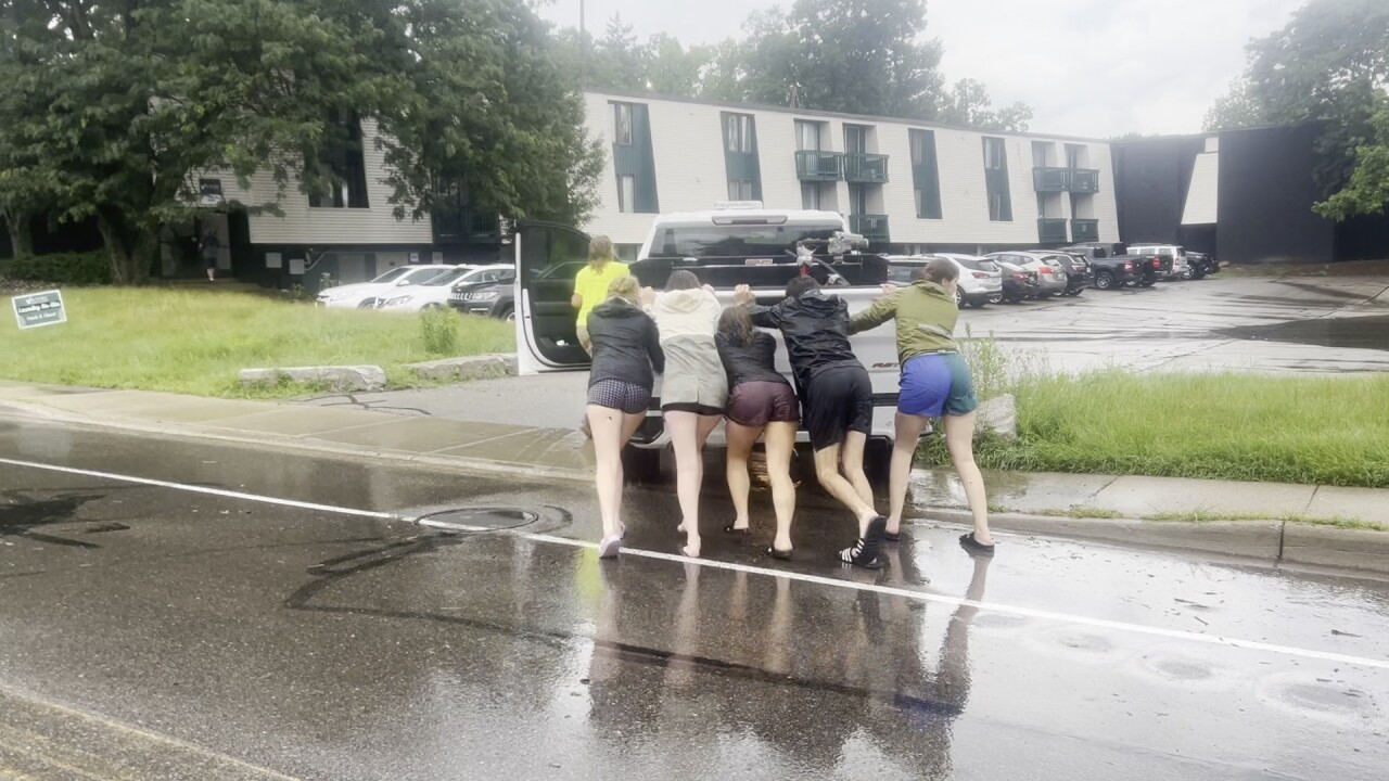 People push truck into parking lot after being stuck in flooded Abbot Road in East Lansing