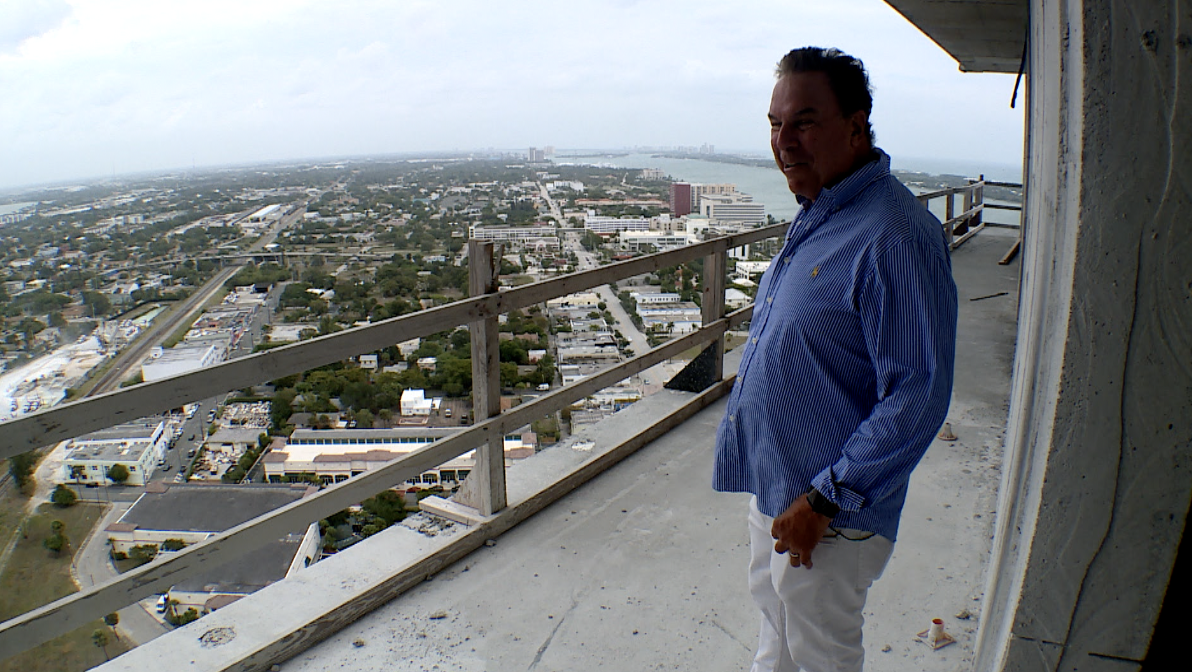 Jeff Greene looks out into West Palm Beach as he stands on unfinished balcony of high-rise towers