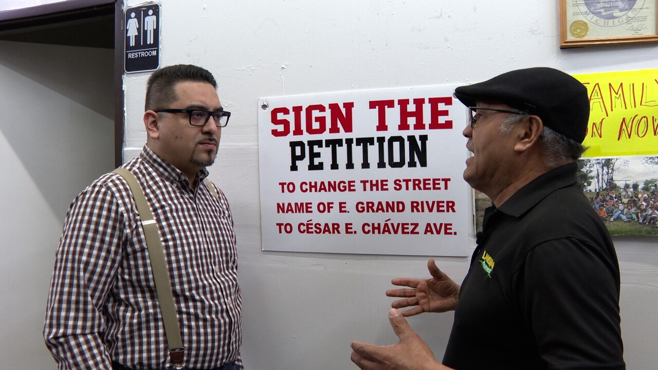 Danny Valle and Alfonso Salas speak in front of Cesar Chavez petition sign