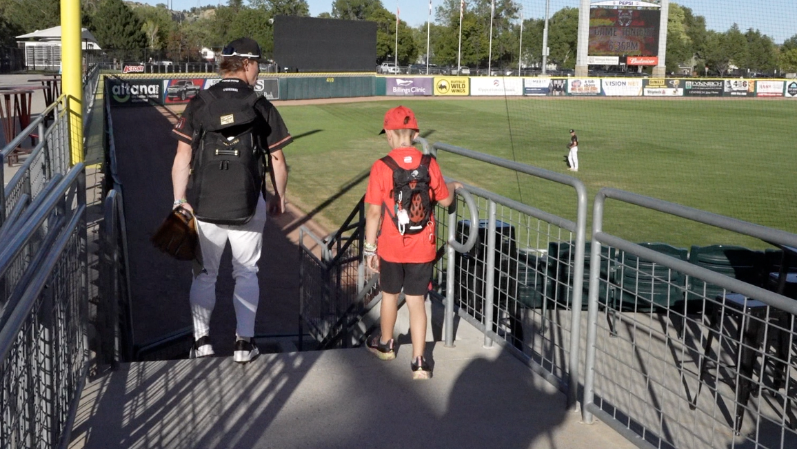 Matty enters the Dehler Park field with a Mustangs player