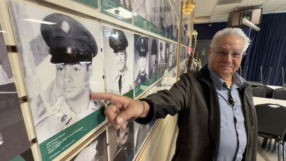 Veteran Ernie Torres points to his picture on the wall inside Mile High Veterans