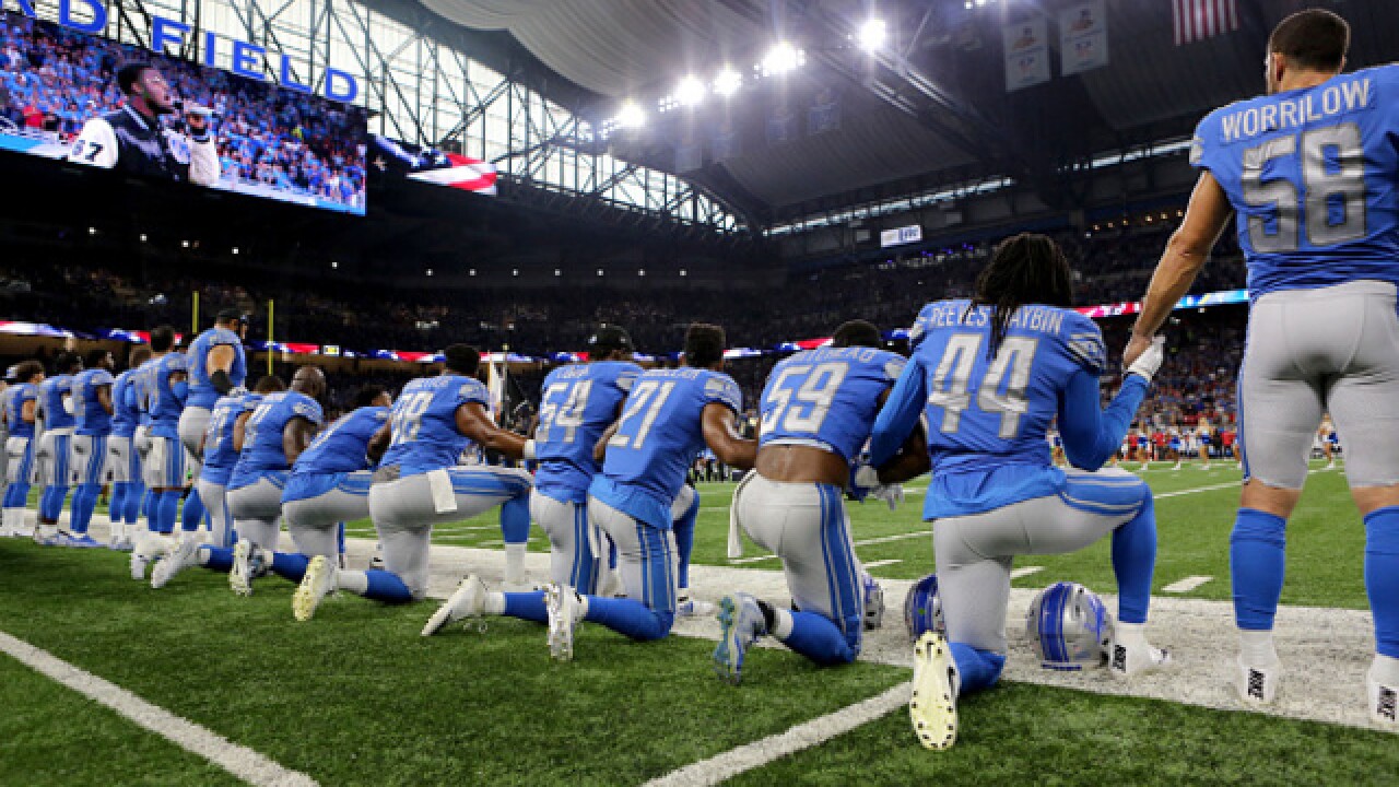 Detroit Lions players take a knee during national anthem