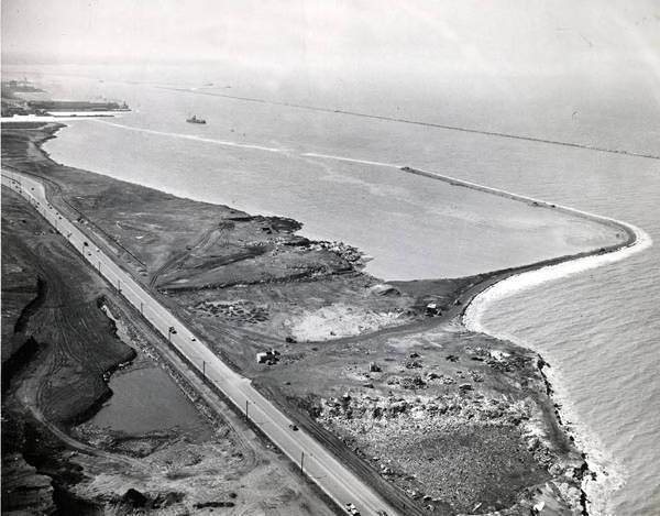 A 1947 aerial photograph shows the Cleveland shoreline and growing man-made land where Burke Lakefront Airport now sits. The airport opened as a dirt runway that year.