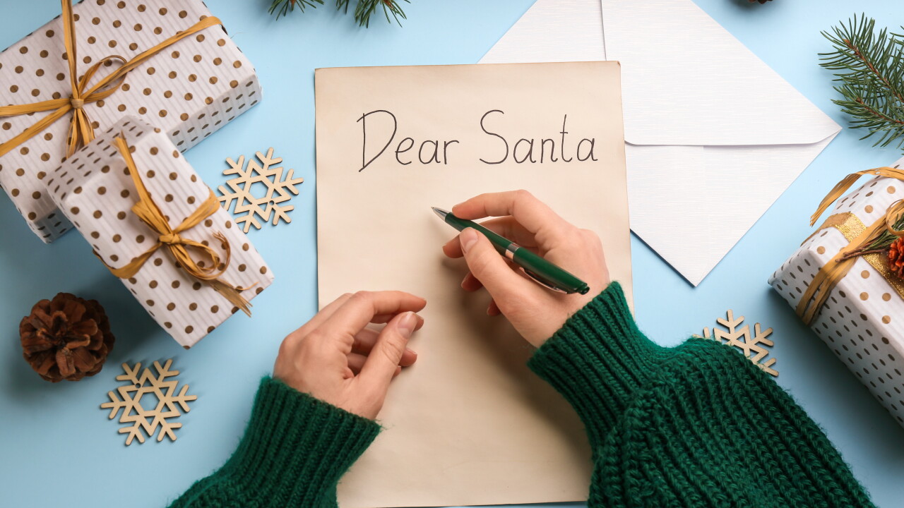 Top,View,Of,Woman,Writing,Letter,To,Santa,At,Light