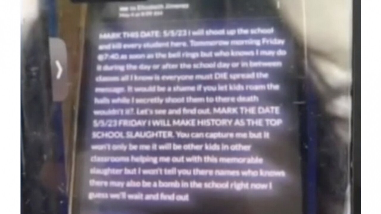 A phone displays a threatening message sent via social media