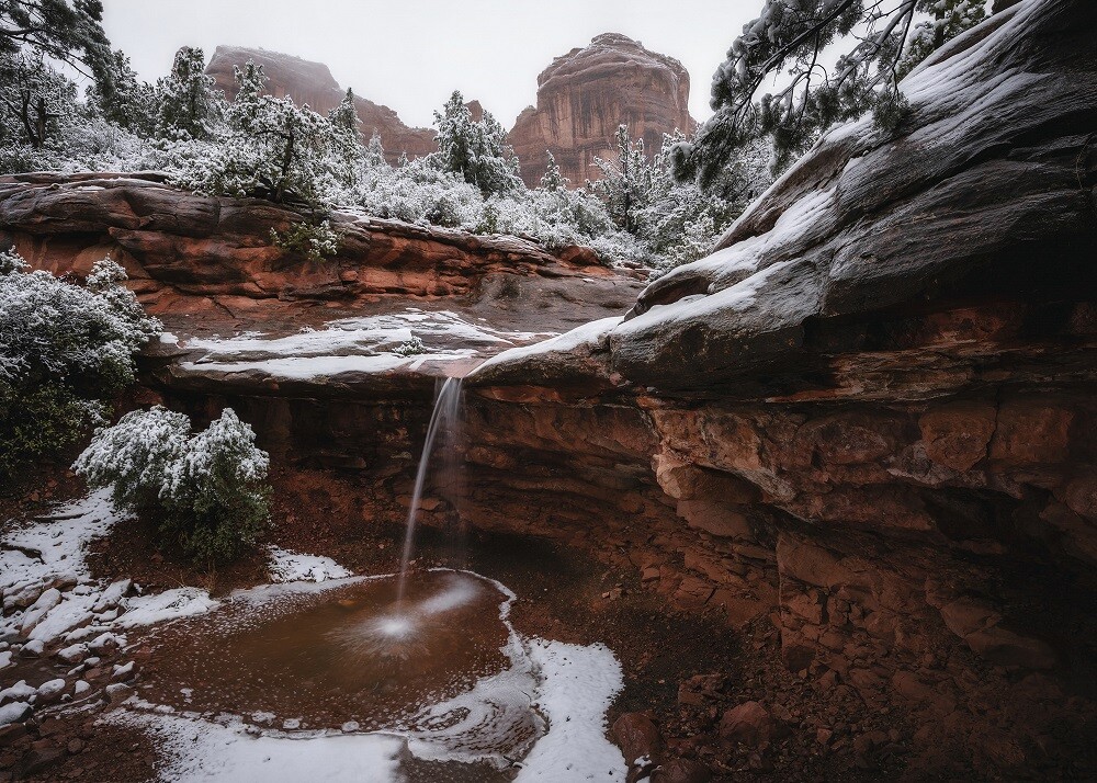 Waterfall appears amid Sedona’s sandstone after a winter storm by Michael Wilson