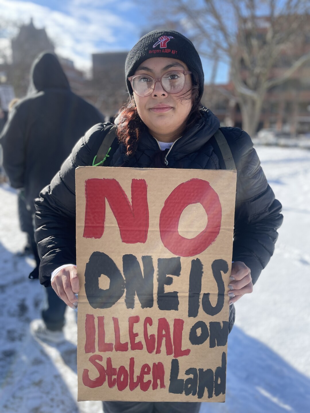 PROTESTOR HOLDS SIGN AT MILWAUKEE PROTEST FOR NATIONAL DAY OF ACTION