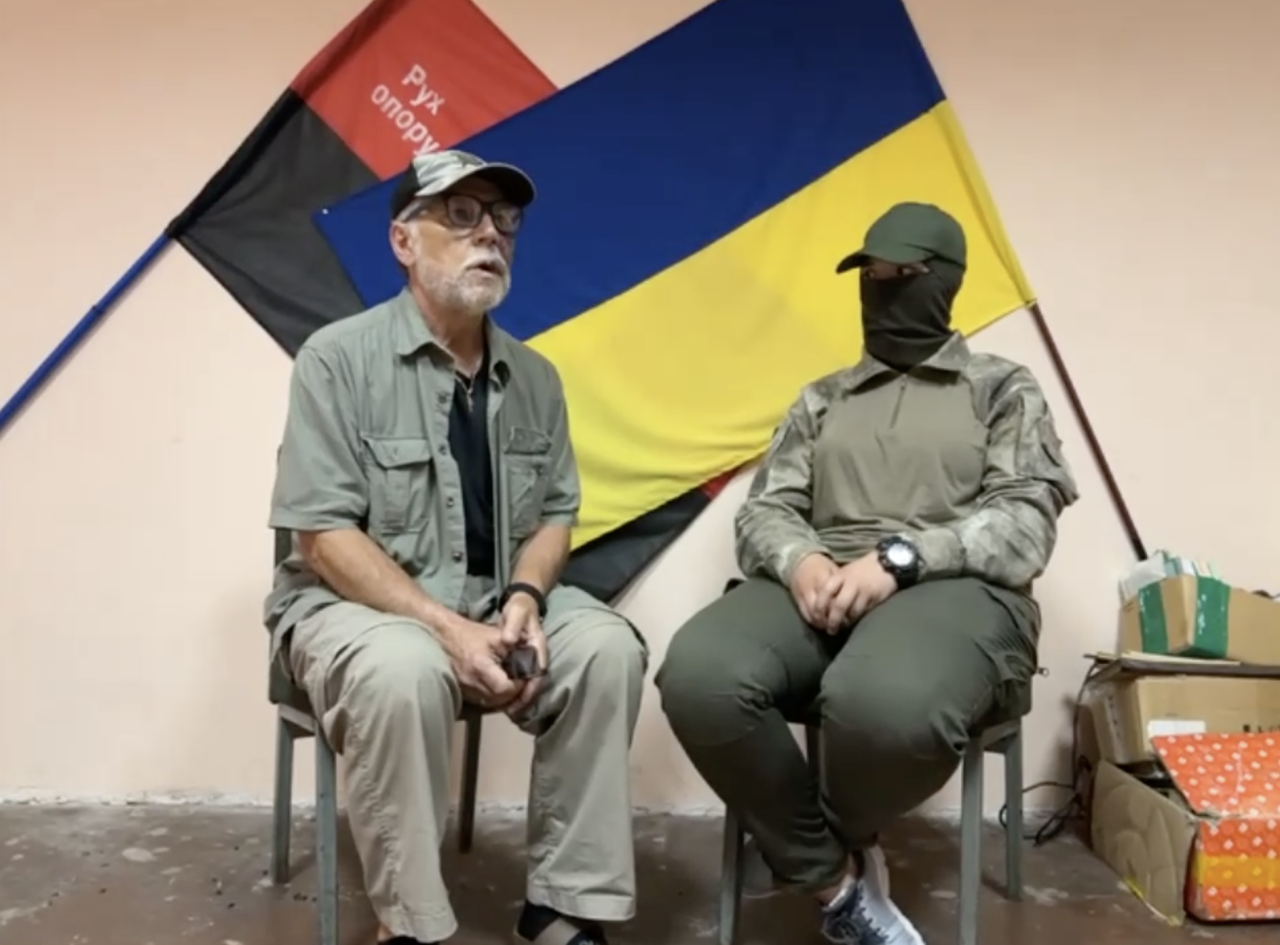 Borys Potapenko (left) sitting with a wounded Ukrainian sniper (right) in the city of Mykolaiv