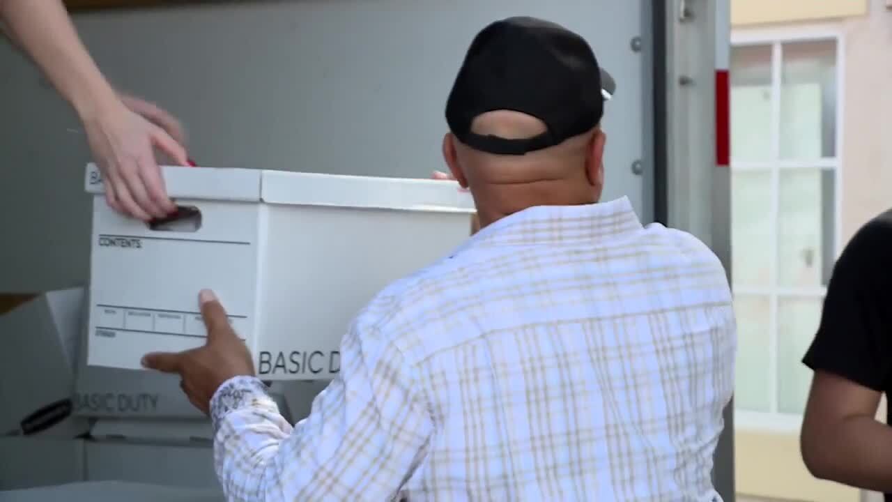 Larry Hardnett aka 'Larry the Turkey Guy' helps remove box of food from truck