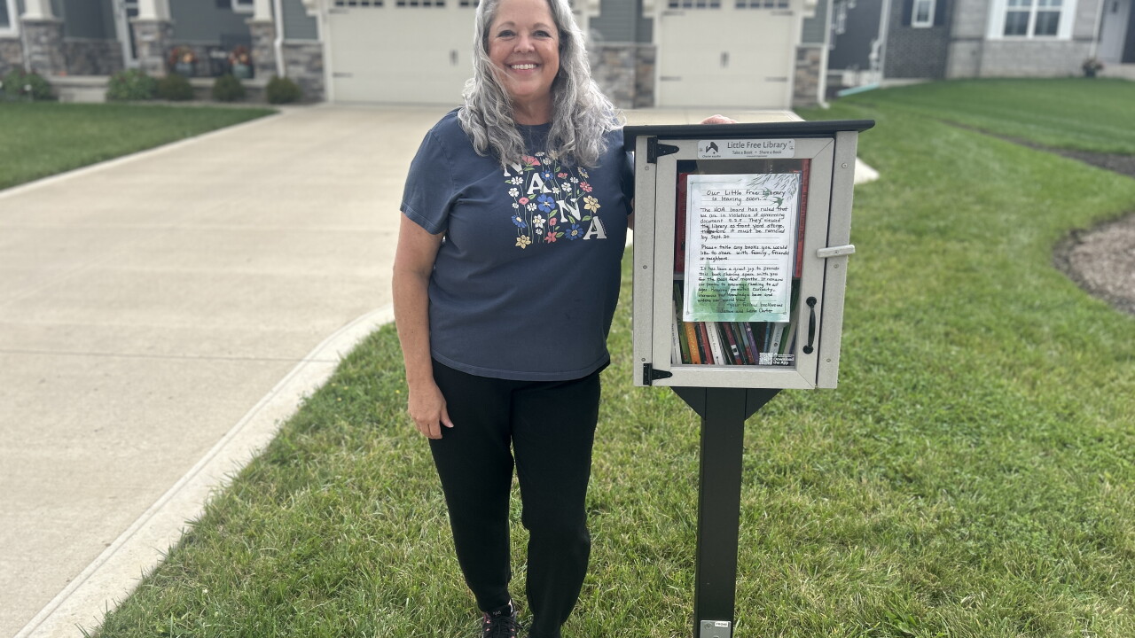 Lana Clark stands next to her free little library in North Ridge Pointe