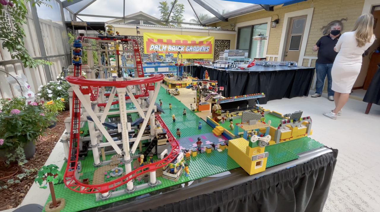 Matthew Perlman speaks to Erica Rakow next to his 'Palm Brick Gardens' Lego city creation