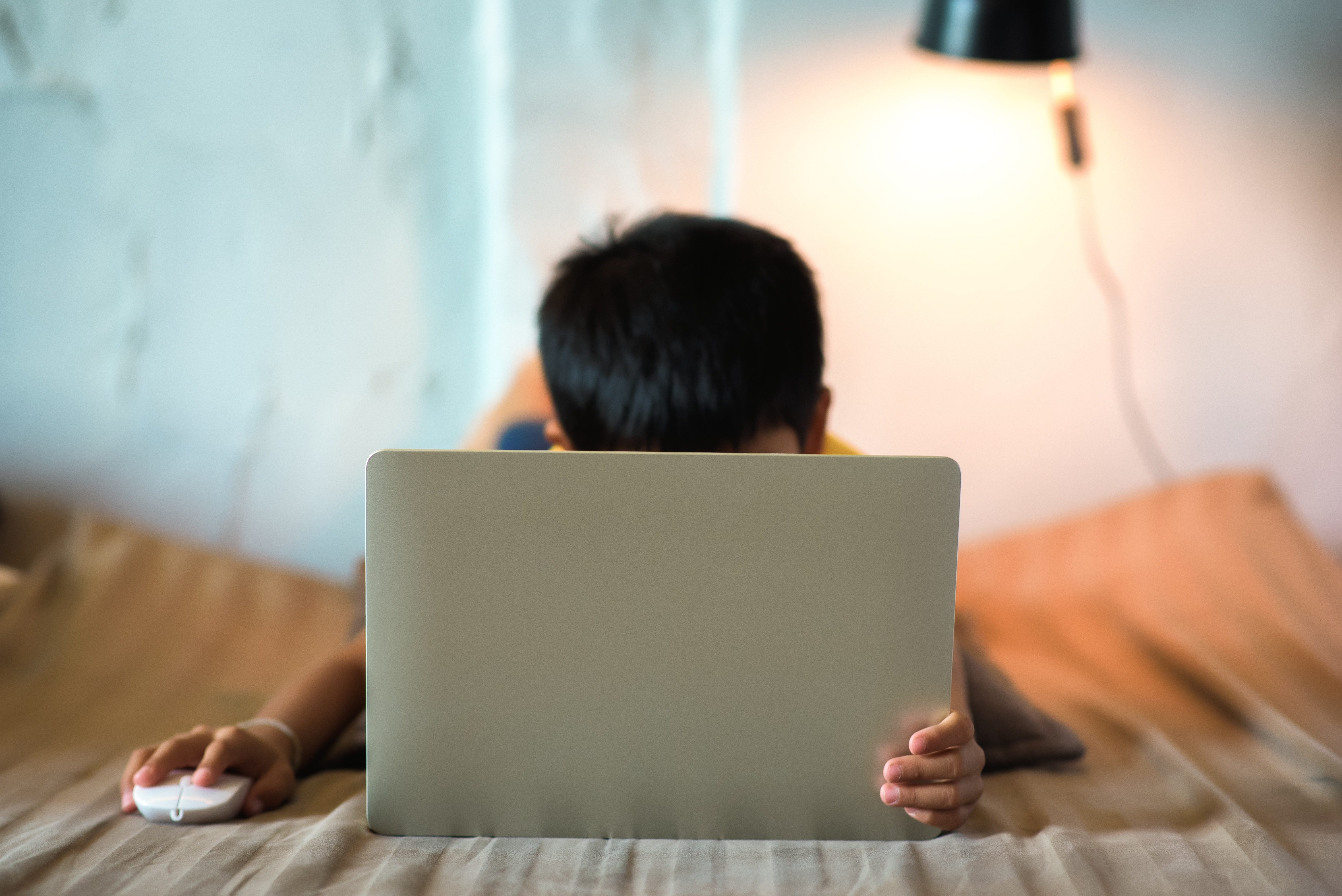 Stock image of a young child on a laptop.