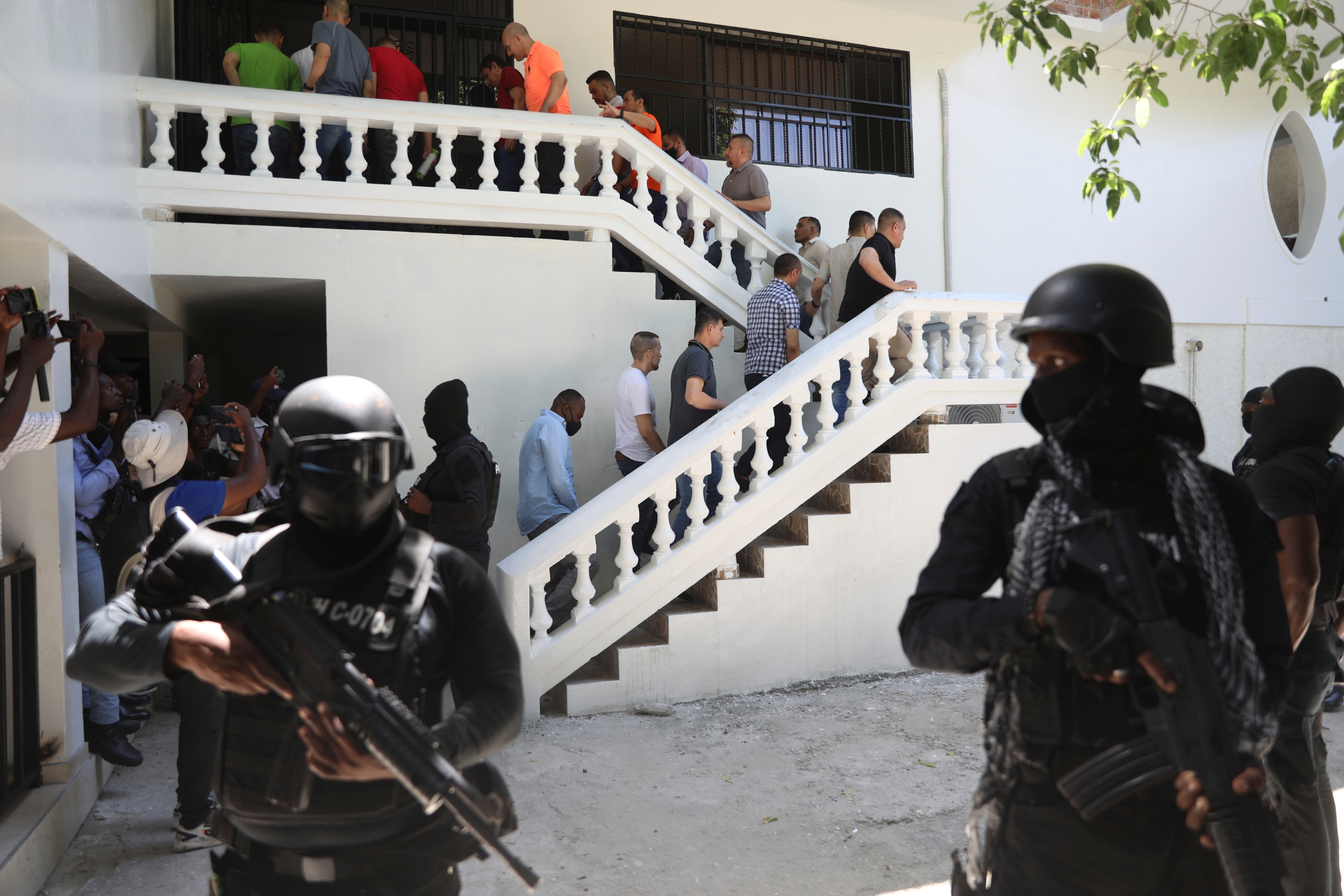 FILE - Colombians and Haitians who are accused of involvement in the 2021 assassination of Haitian President Jovenel Moise are escorted in handcuffs to their court hearing in Port-au-Prince, Haiti, May 26, 2025.