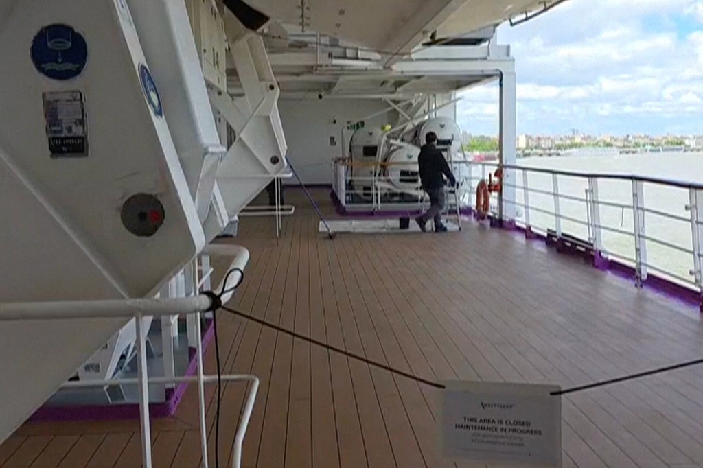 A man walks on a deck of the British cruise ship the Ambition after 1,700 passengers and crew were ordered to remain on board after an outbreak of gastrointestinal illness, in the port of Bordeaux, France, Wednesday, May 13, 2026.