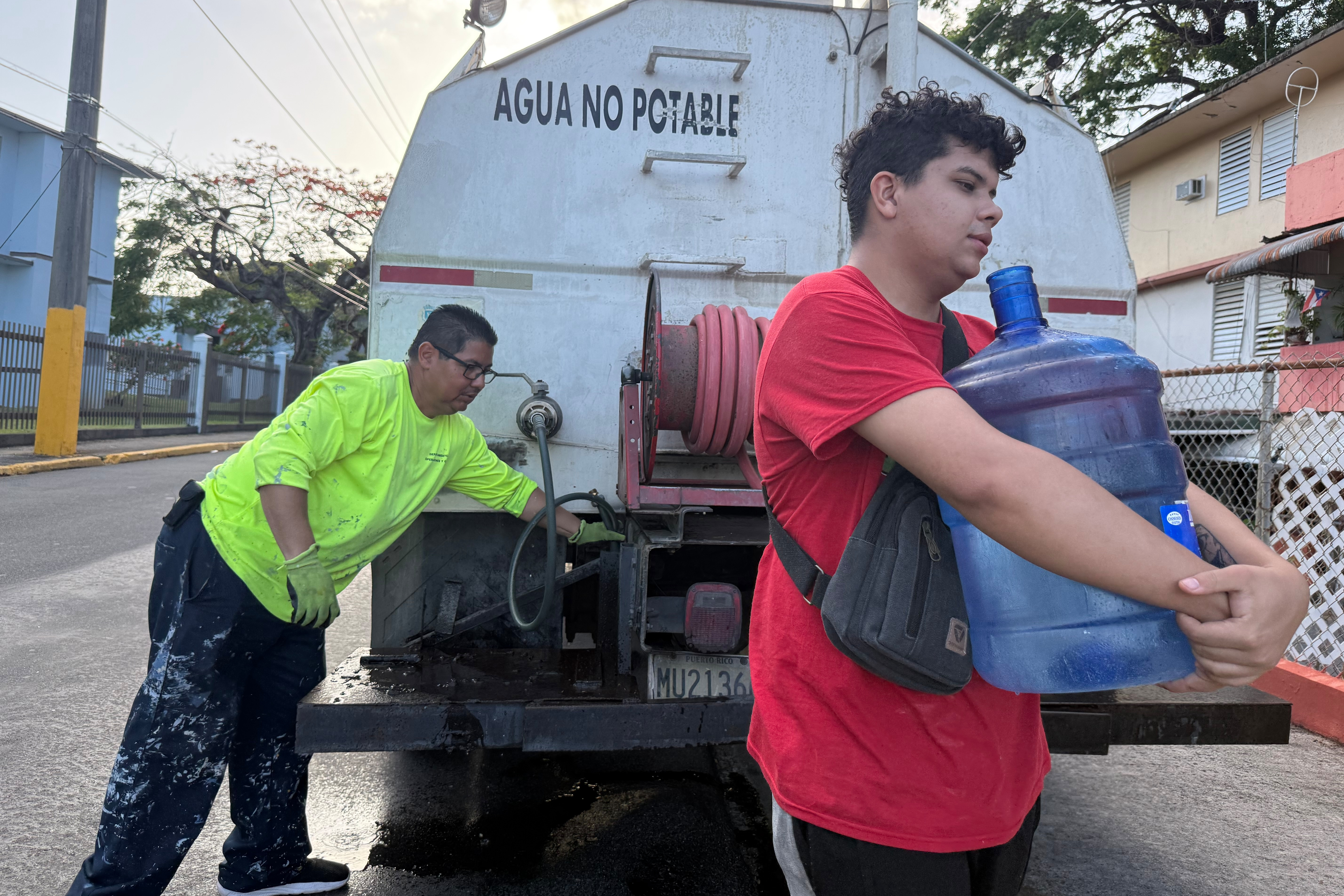 Bryan Pérez hauls a five-gallon water jug to his apartment in the Villa Kennedy public housing complex in San Juan, Puerto Rico, Wednesday, June 10, 2026. 