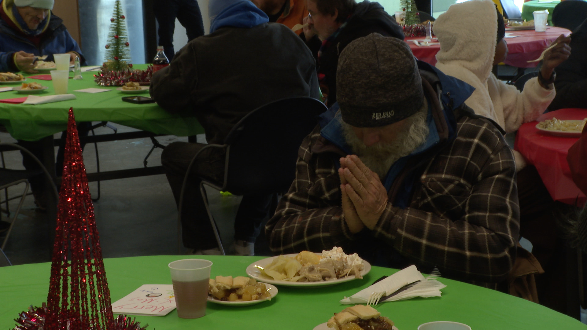 Springs Rescue Mission resident, Terry Sisk, prayed before his free meal this Christmas.