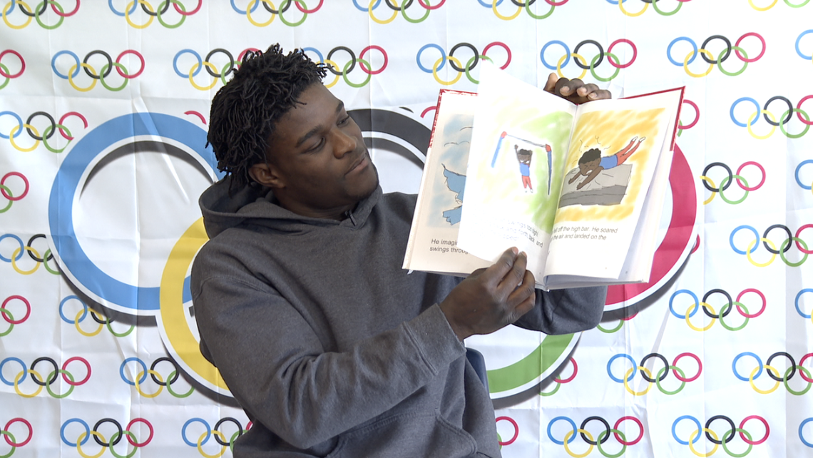 Federick Richard reading a story to preschoolers at The Learning Experience in South Lyon about a black male gymnast who achieves his dreams.