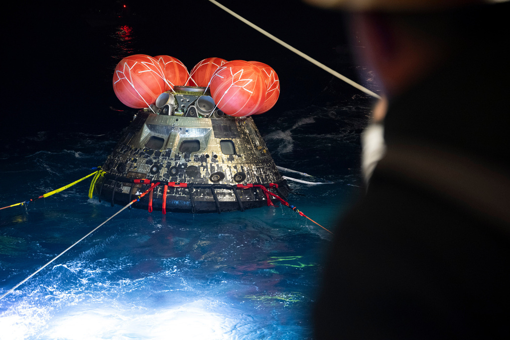 In this photo provided by NASA, NASA's Orion spacecraft is seen as the agency's Landing and Recovery team, along with U.S. Navy personnel work to recover the spacecraft into the well deck of USS John P. Murtha in the Pacific Ocean off the coast of California, Saturday, April 11, 2026. 