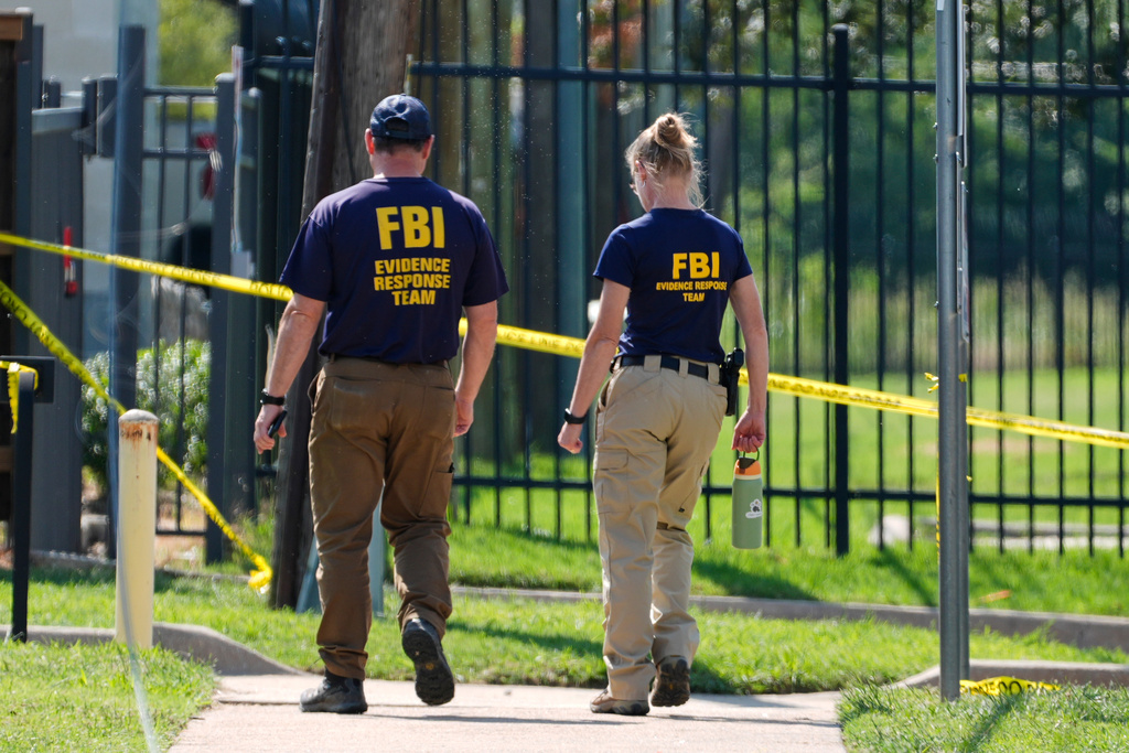 FBI agents investigate the crime scene near a U.S. Immigration and Customs Enforcement office on Thursday, Sept. 25, 2025, in Dallas. 