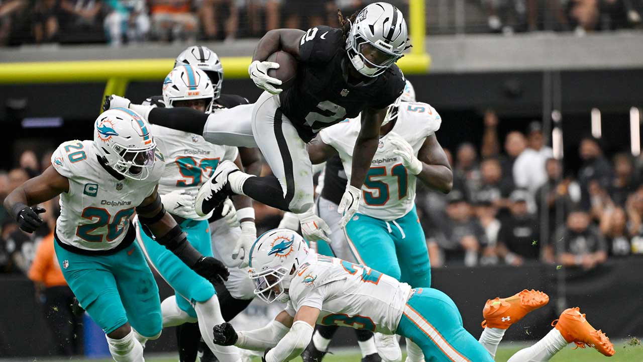 Las Vegas Raiders running back Ashton Jeanty (2) leaps over Miami Dolphins linebacker Jordyn Brooks (20) and safety Zayne Anderson (23) during the second half of an NFL football game, Sunday, Sept. 13, 2026, in Las Vegas. 