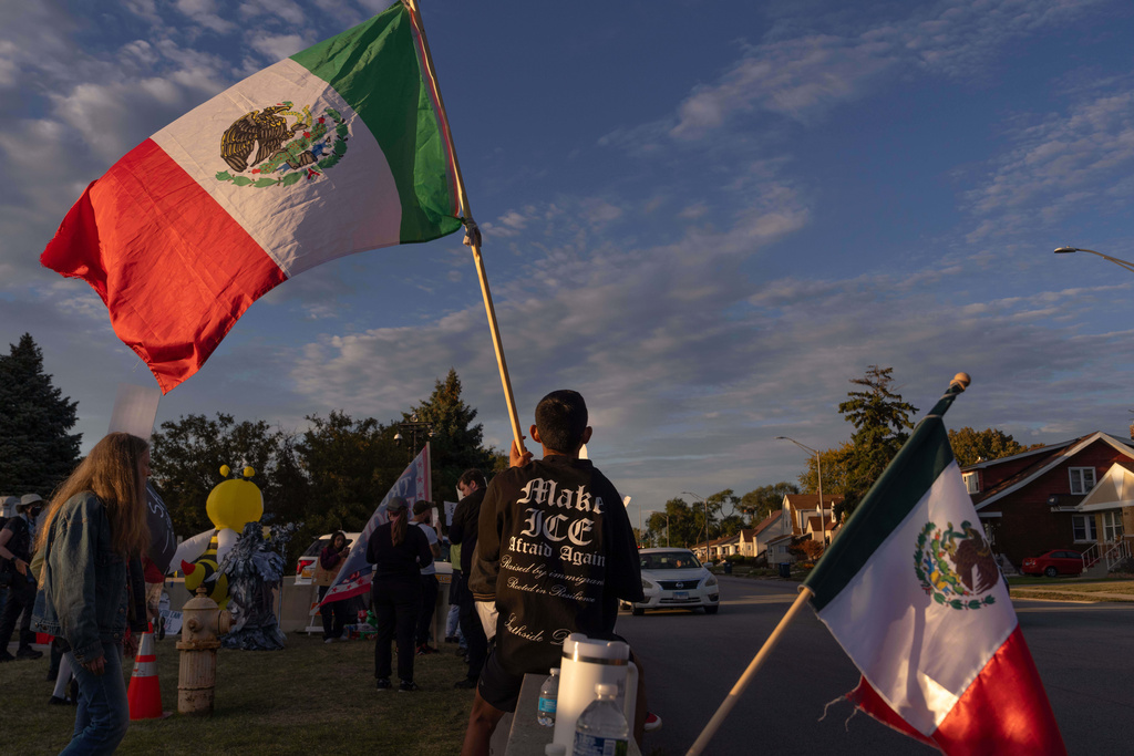 A protester holds a Mexican flag as they wear a 'Make ICE Afraid Again' T-shirt outside of the U.S. Immigration and Customs Enforcement facility in Broadview, Ill., Sunday, Oct. 12, 2025. 