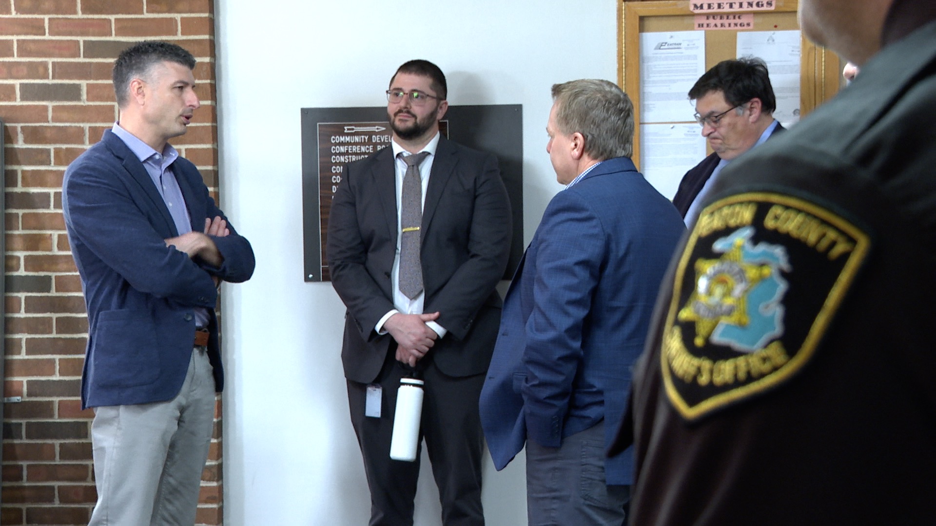 Eaton County Sheriff's Office Patch in foreground with U.S. Rep. Tom Barrett speaking to county leaders