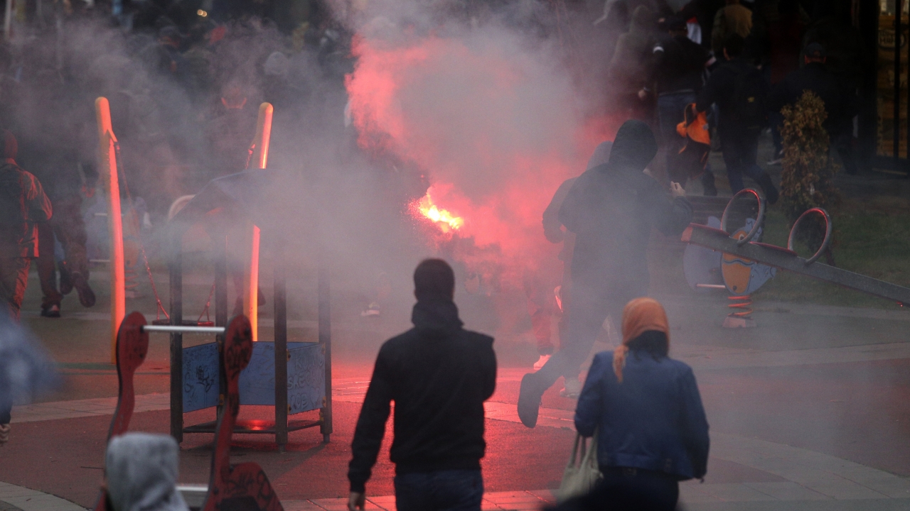 Anti-LGBTQ protesters throw a flare during a pride march.