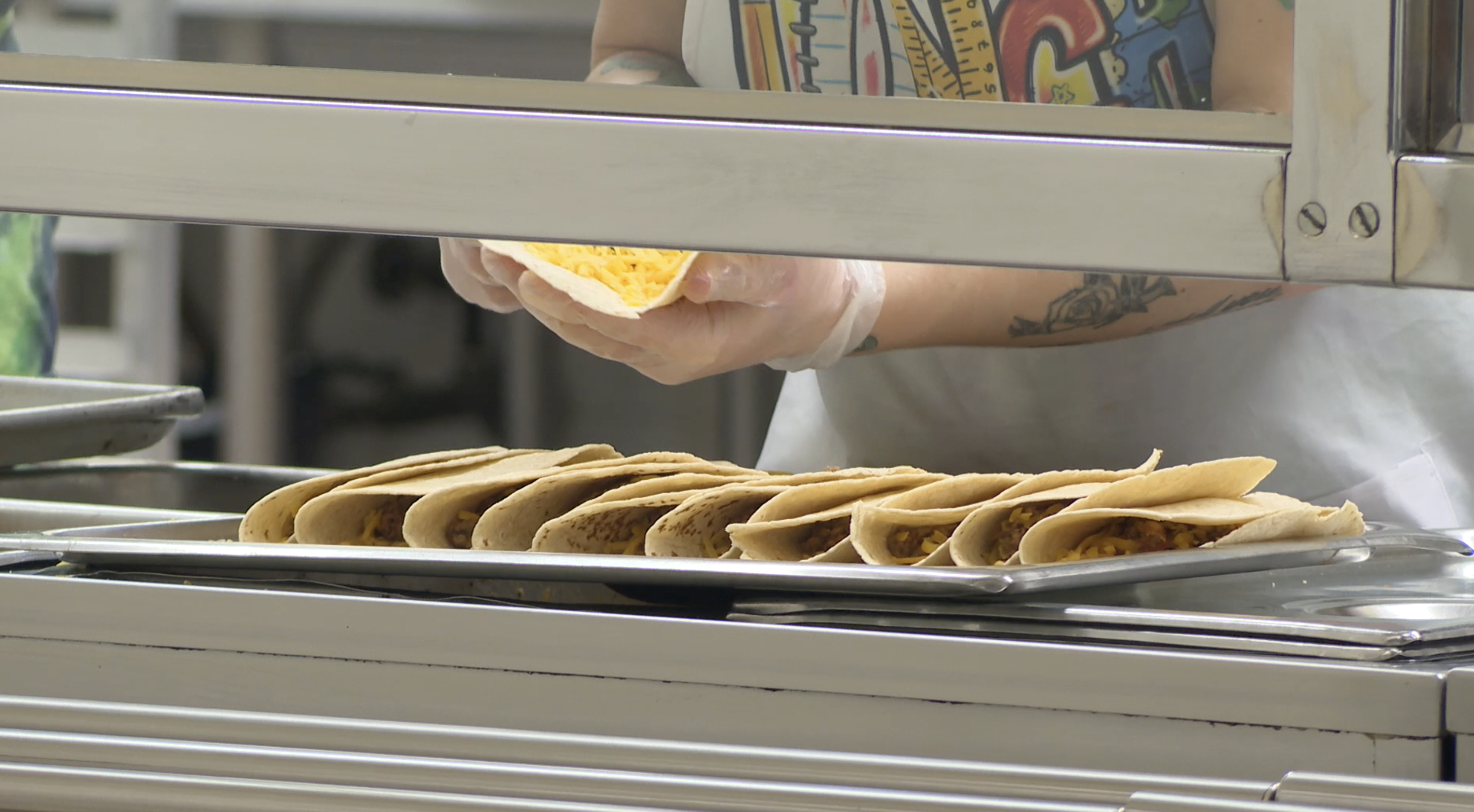 A food service worker prepares tacos on Tuesday, Oct. 15, 2024, in the cafeteria at Robert Stuart Middle School