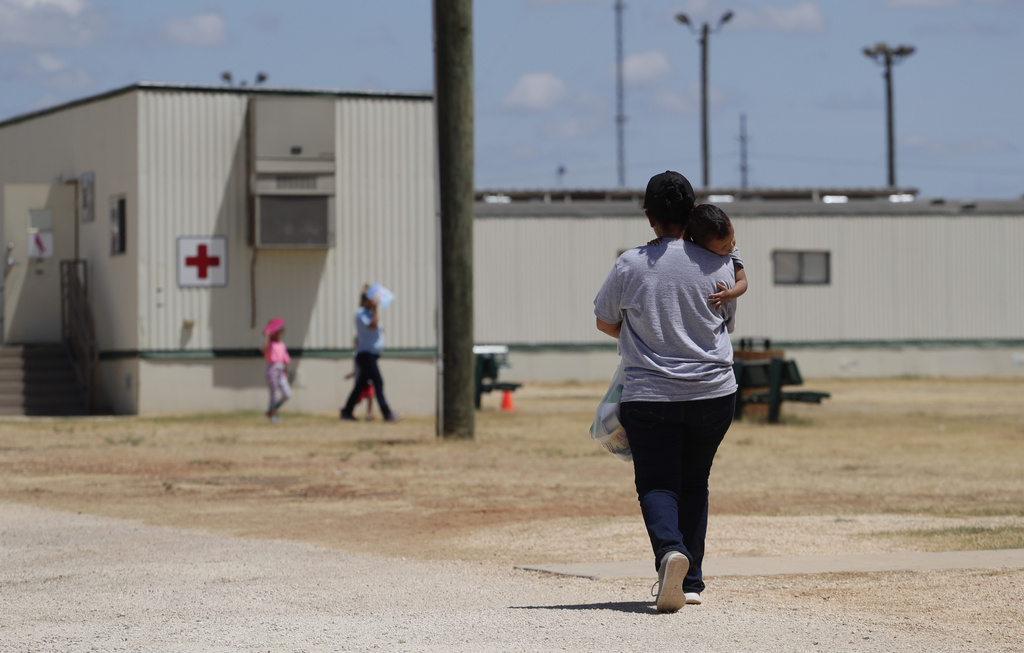 Immigrants seeking asylum walk at the ICE South Texas Family Residential Center, Aug. 23, 2019, in Dilley, Texas. 