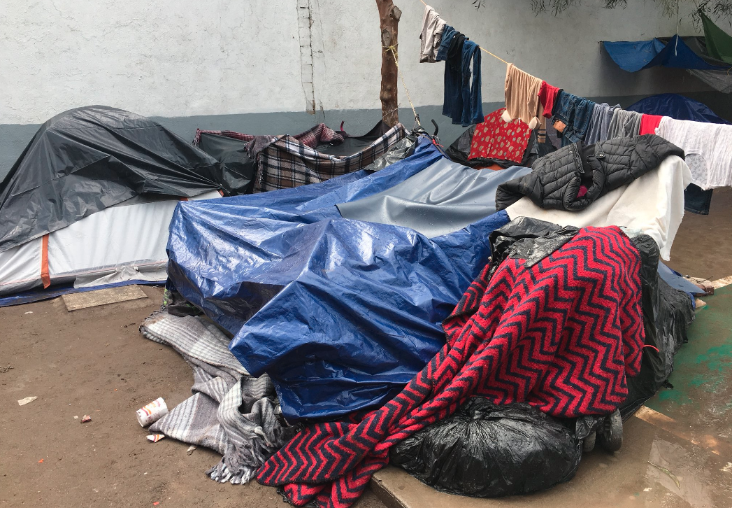 Migrants in Tijuana take shelter from the rain