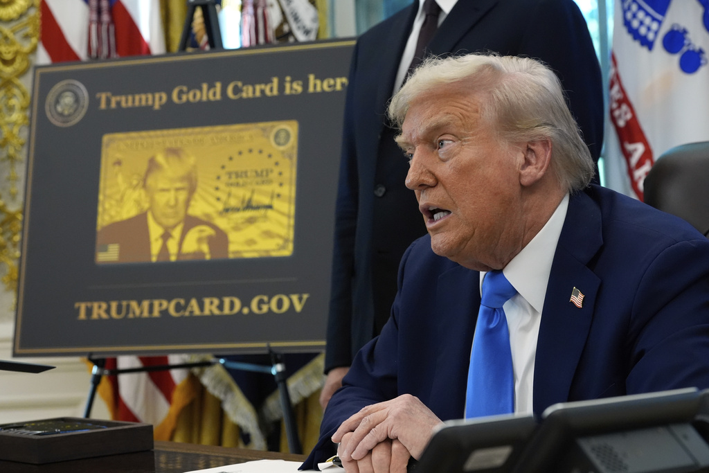 A poster showing the Trump Gold Card is seen as President Donald Trump signs executive orders in the Oval Office of the White House, Friday, Sept. 19, 2025, in Washington.