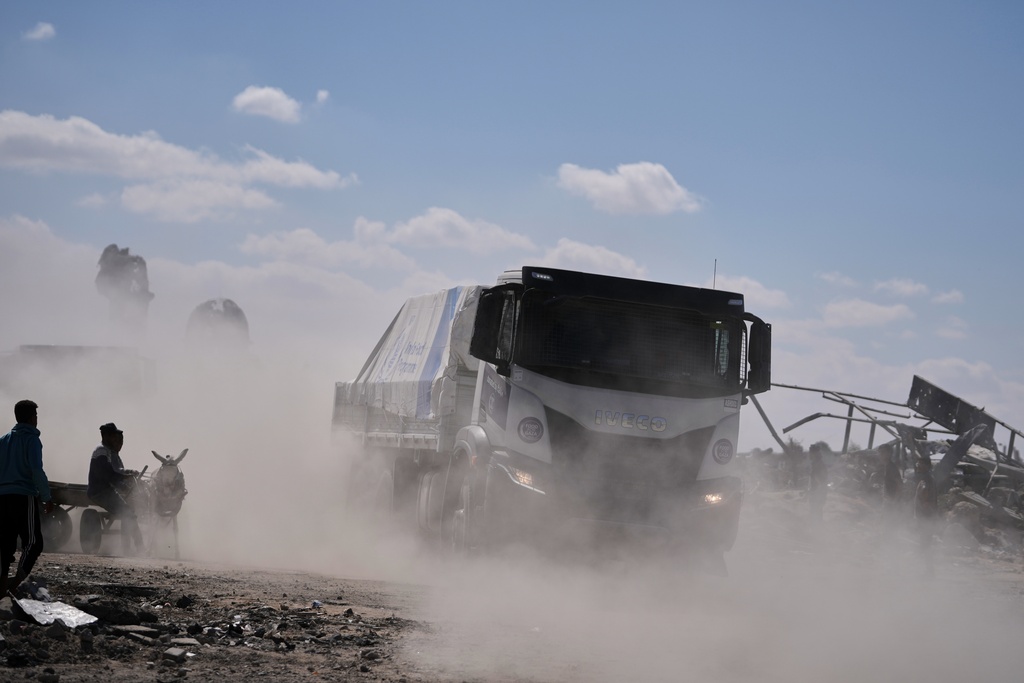 Trucks carrying aid from the World Food Programme (WFP) drive through in Khan Younis, southern Gaza Strip, Wednesday, Oct. 15, 2025.