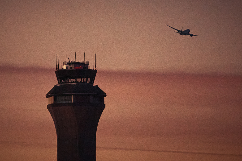A plane flies by a control tower at Newark Liberty International Airport on Nov. 7, 2025, in Newark, N.J. 