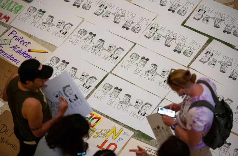 Illustrated posters reading “We Belong Here” on the Texas Capitol’s rotunda floor during Texas Students for Diversity, Equity and Inclusion’s protest of HB1 Rider No. 186, which would defund DEI initiatives at public universities, on March 23, 2023.