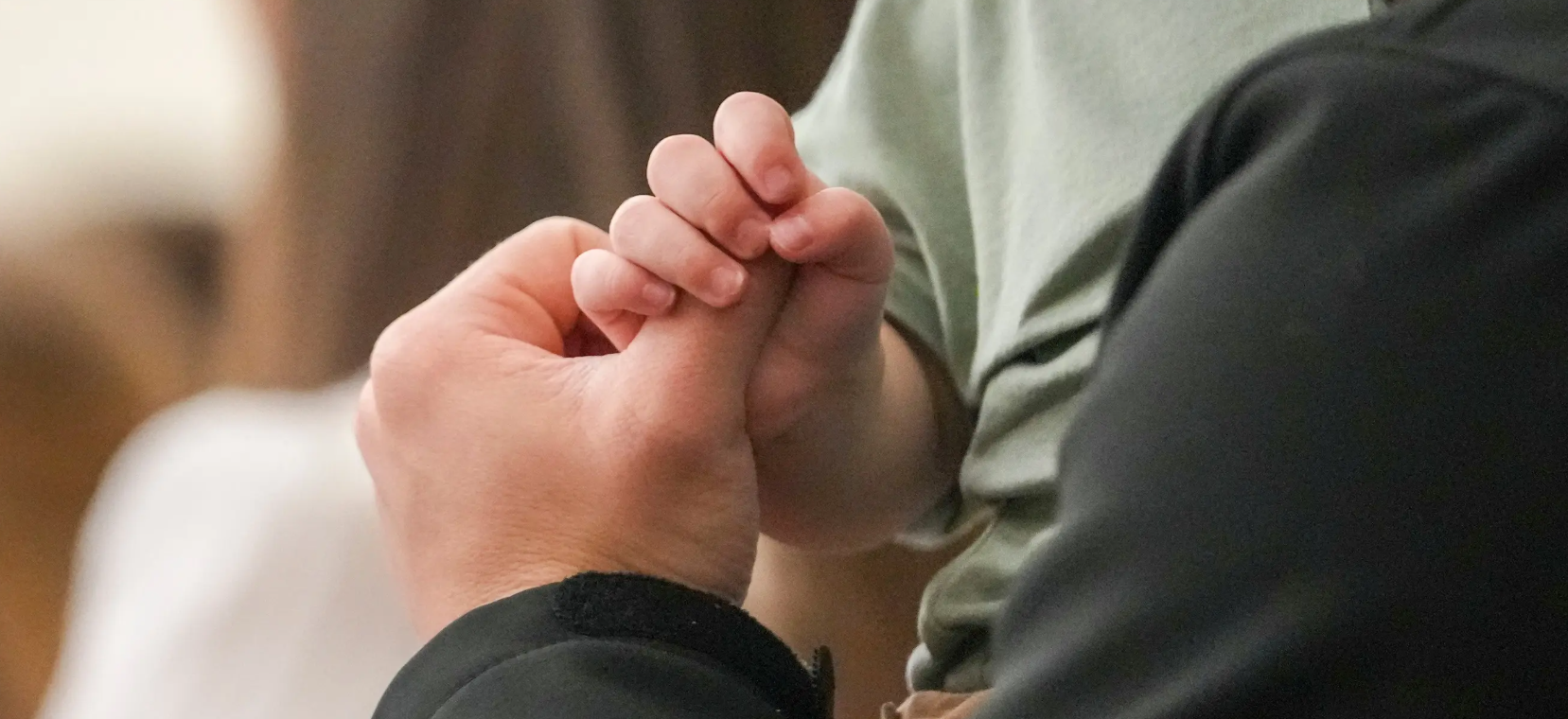 A child holds a man’s thumb during a service at Community Church of Seminole on Sunday.p