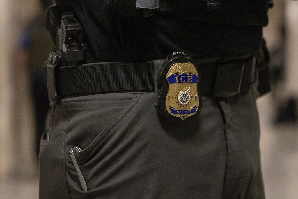 A federal agent wears a badge of Immigration and Customs Enforcement at the immigration court at Jacob K. Javits Federal Building in New York, Monday, June 9, 2025. 