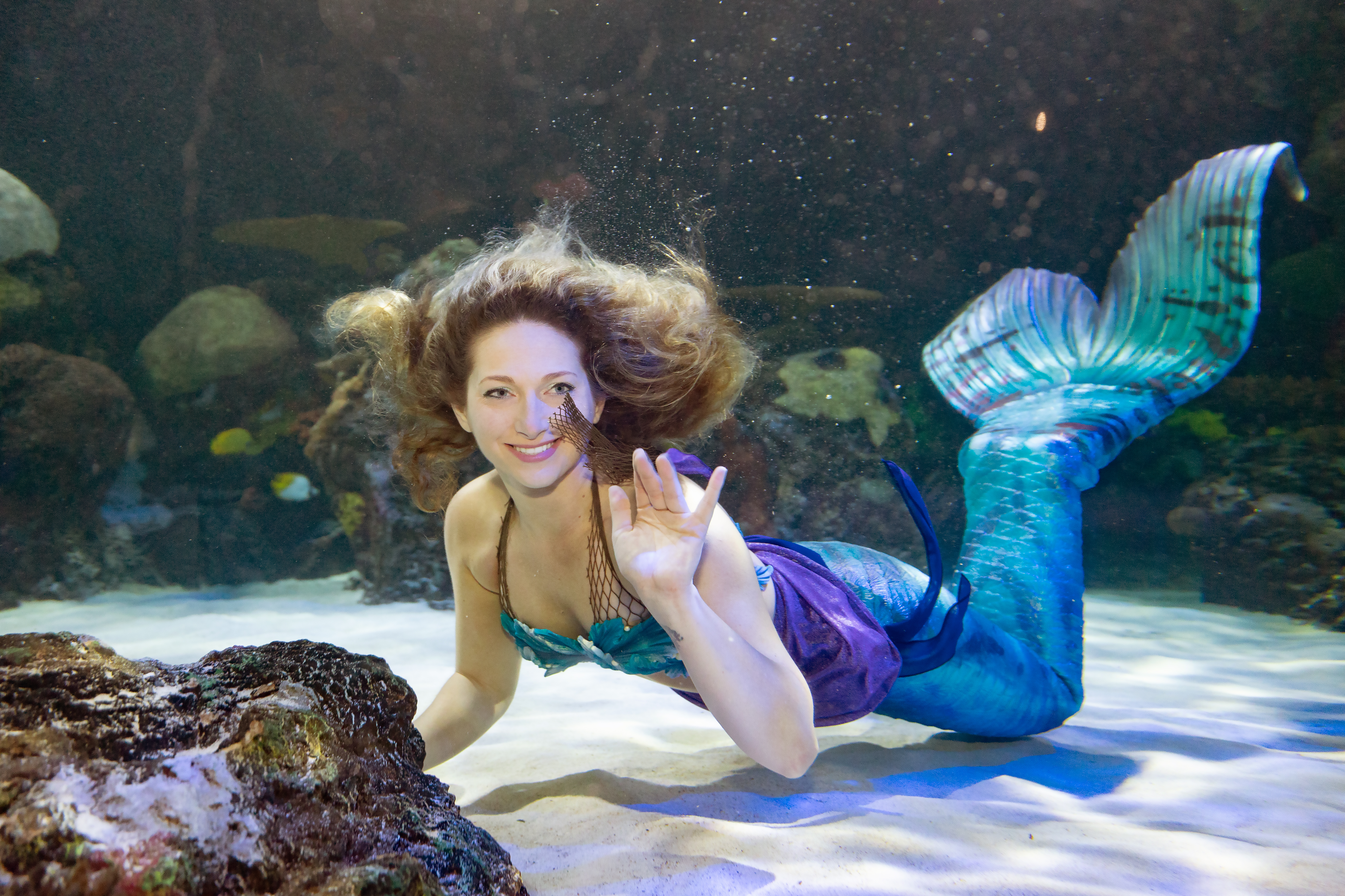 Mermaid in the Virginia Aquarium Red Sea Tunnel waving at the camera