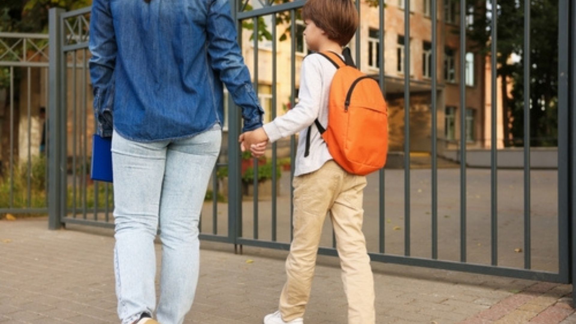 Stock image of a mother walking her son to school.