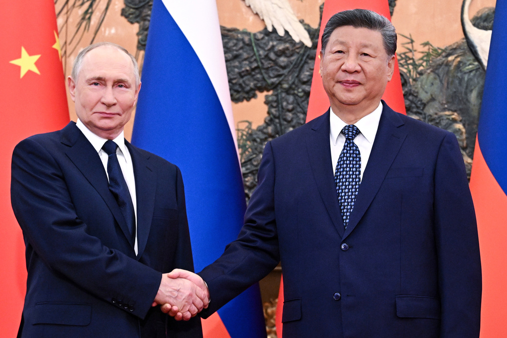Russian President Vladimir Putin, left, and Chinese President Xi Jinping shake hands ahead of their meeting at The Great Hall of the People in Beijing, China.