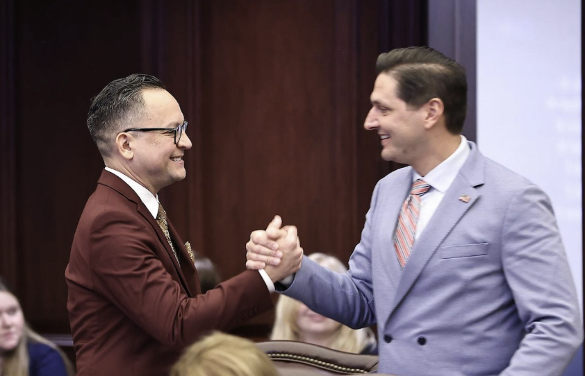 Sen. Carlos Guillermo Smith, a Democrat, celebrates with Sen. Danny Burgess, a Republican, as their bill advances