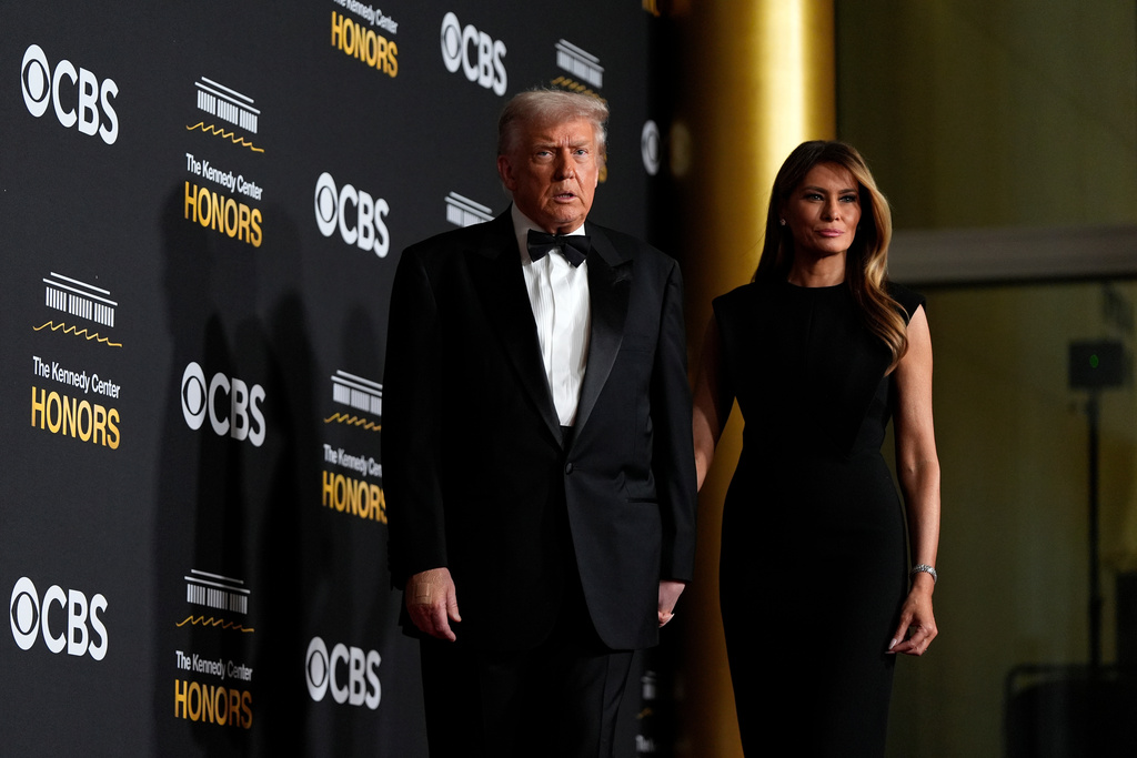 President Donald Trump and  first lady Melania Trump, walk the red carpet before the 48th Kennedy Center Honors, Sunday, Dec. 7, 2025, at the John F. Kennedy Center for the Performing Arts in Washington.