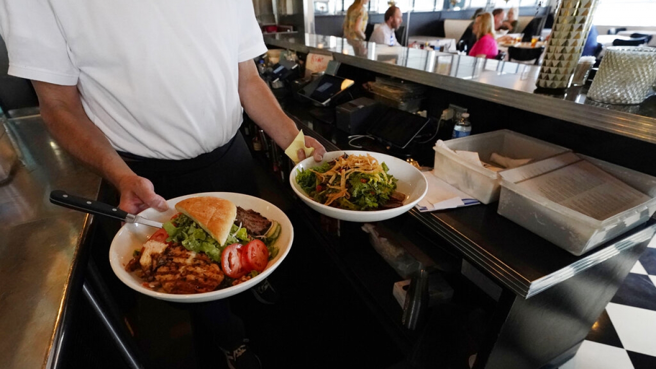 Richard Kennington of Walker's Drive-In, carries out meals to customers.