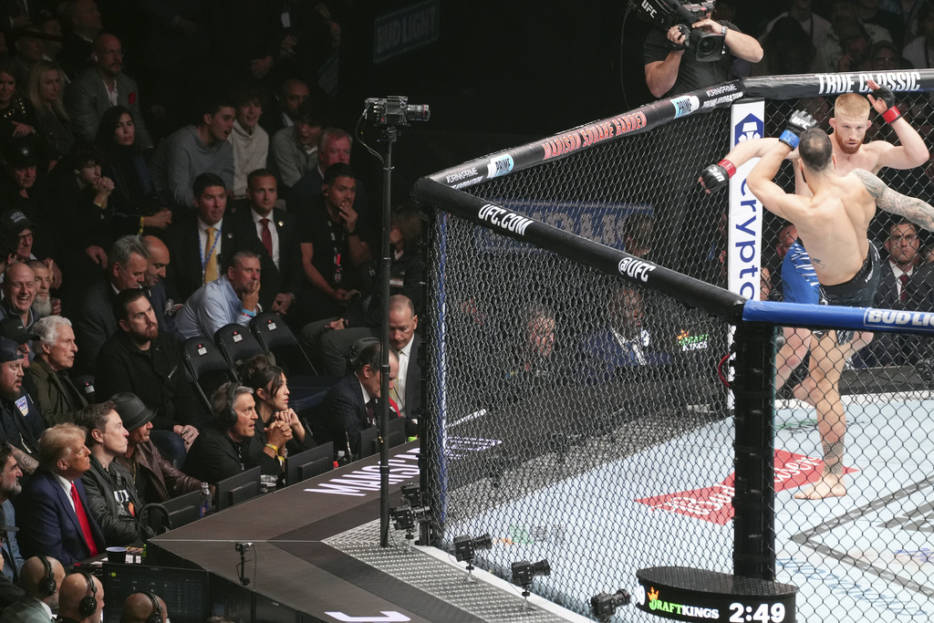 President-elect Donald Trump watches as Bo Nickal, facing camera, fights Scotland's Paul Craig at UFC 309 at Madison Square Garden, Saturday, Nov. 16, 2024, in New York. 
